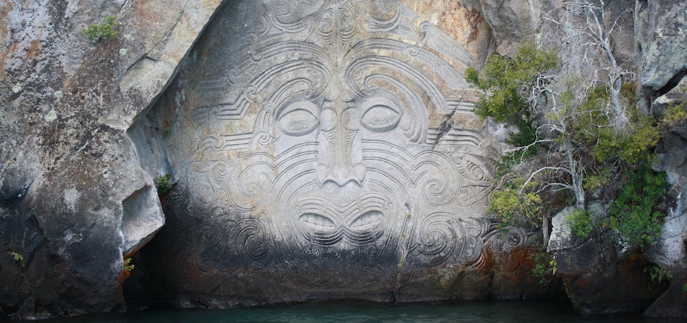 Photo of a Maori sculpture in a rock.